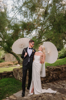 Bride and groom pose with umbrellas; Jessica and Liam – A Joyful Tuscan Wedding at Casa Cornacchi