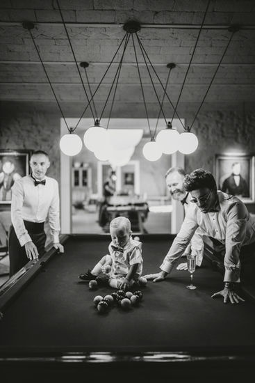 People play pool with child in a game room, wedding at Vignamaggio.