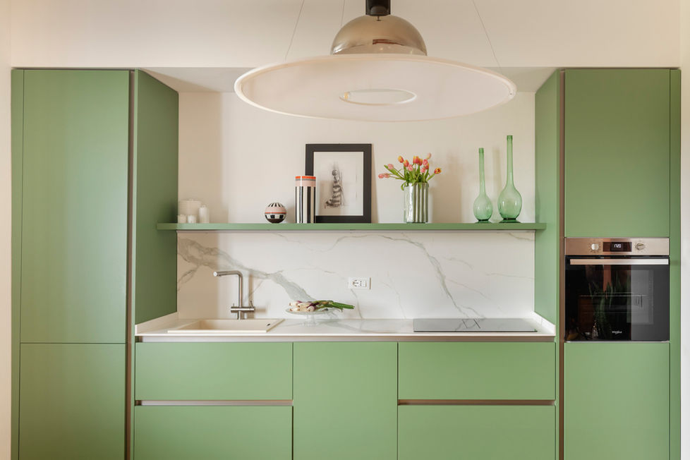 Cucina moderna verde salvia con ripiano in marmo bianco.