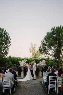 Wide view of the outdoor ceremony with floral and pampas grass arrangements.