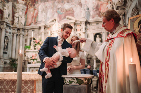 Priest baptizing a baby with parents watching inside a church, baptism ceremony riccardopieri