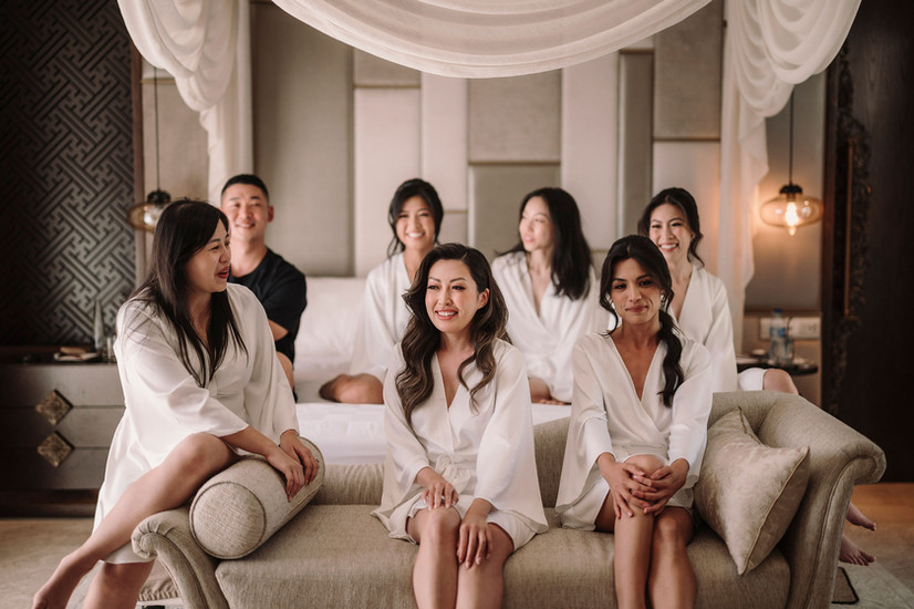 Group of women in white robes smiling on sofa. Anya and Ray – Luxury Wedding at Ayana Resort Bali
