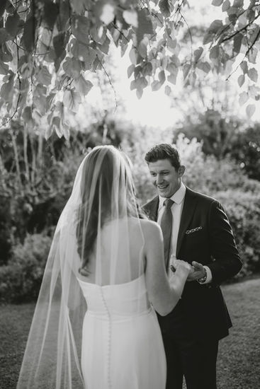 Emotional moment between bride and groom during the outdoor ceremony in black and white