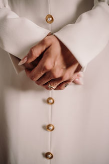 Bride hands detail with ring and white dress
