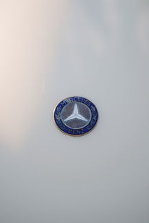 Close up of the Mercedes emblem on the vintage car hood.