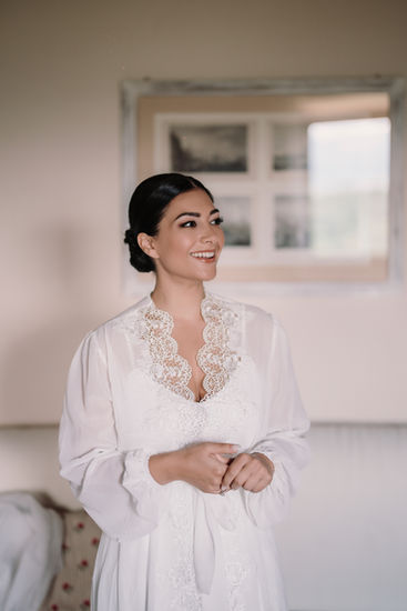 The bride smiling while getting ready in the soft morning light at Castello di Vicchiomaggio.