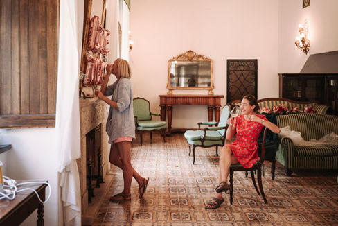 Two women decorate with balloons, one in red dress, Luxury Wedding at La Badia di Orvieto, indoor setting.