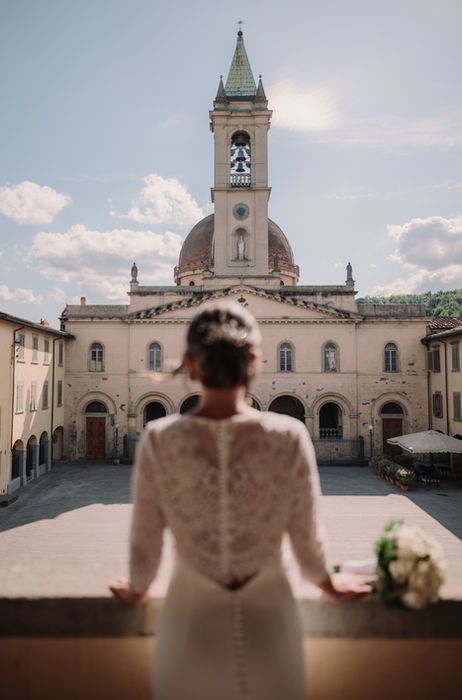 Bride overlooking historic Tuscan architecture before the wedding ceremony