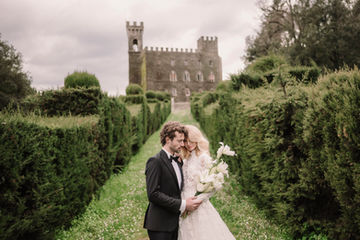 Couple at Tuscan castle with cypress trees