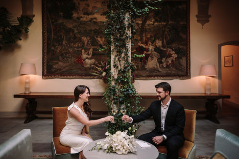 Alyssa and Sean toasting, seated in elegant room, classic elopement at Belmond Villa San Michele Florence