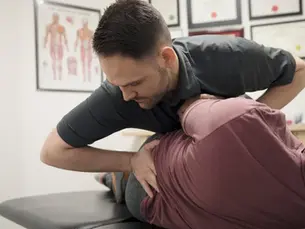 Chiropractor performing a gentle spinal adjustment on a patient at Barto Family Chiropractic in Monroeville PA