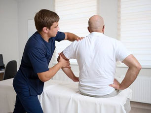 Chiropractor examining patient's neck after car accident at Barto Family Chiropractic in Monroeville PA