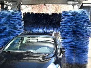 Touchless car wash system cleaning vehicle with high-pressure water jets at Three Rivers Car Wash Western Pennsylvania location