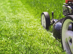 Professional lawn mowing service on a sloped residential property in Irwin PA by Dombrowski Projects