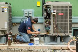 Professional central air installation technician working on outdoor unit in Somerset, PA residential setting