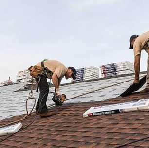 Roofing crew completing a roof replacement on a Pittsburgh-area home on a clear day