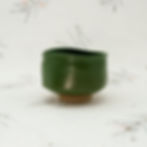 Green ceramic matcha bowl by EngiCrafts with a semi-gloss finish, subtle ridges, and an organic, slightly uneven rim.