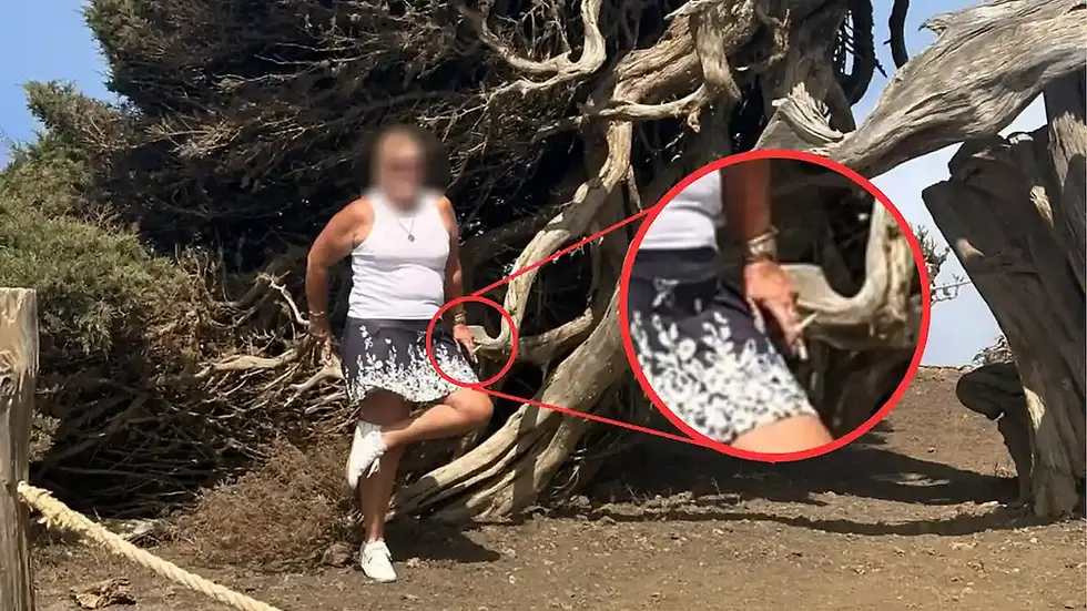 Una mujer salta el cordón que protege a la Sabina de El Hierro para hacerse una foto con un cigarro en la mano
