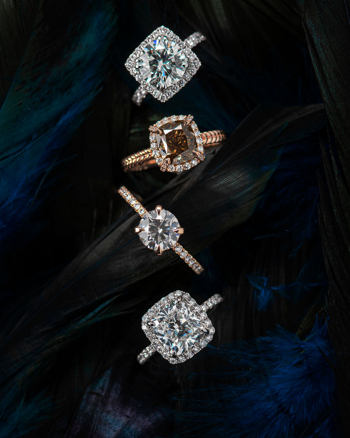 Elegant luxury jewelry photography showcasing multiple diamond rings on a rich black satin background, captured by KV Media Group in Dallas.