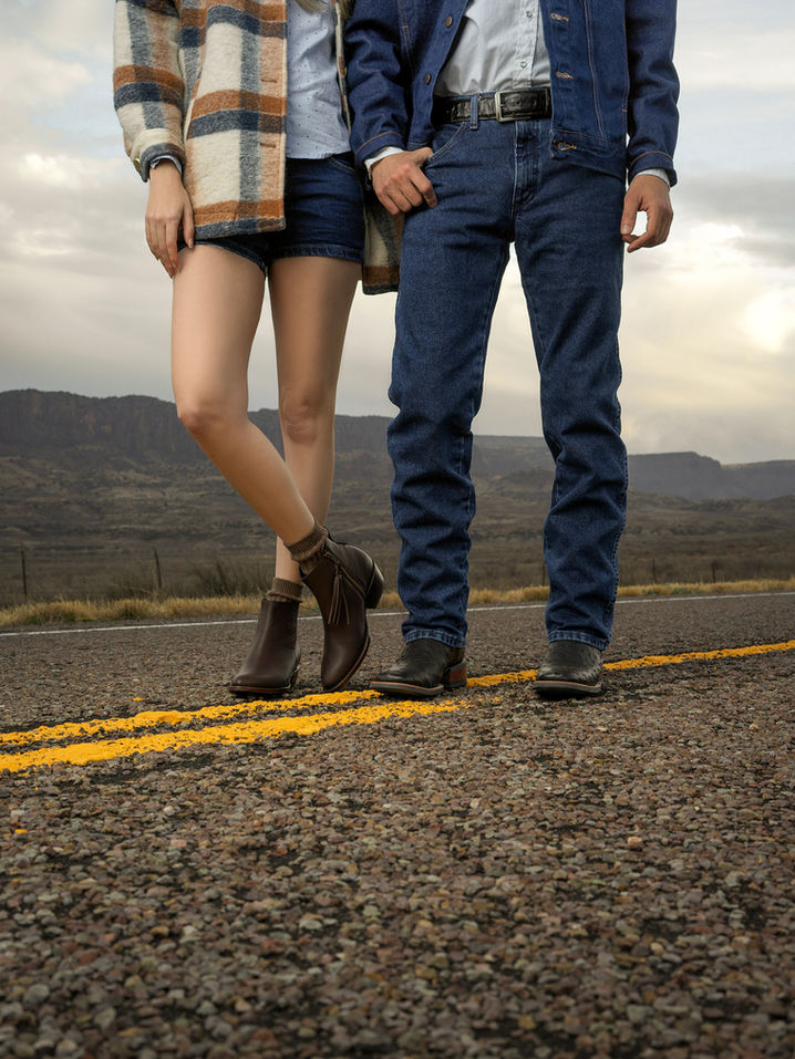 Man and woman walking hand-in-hand on a quiet Texas road.