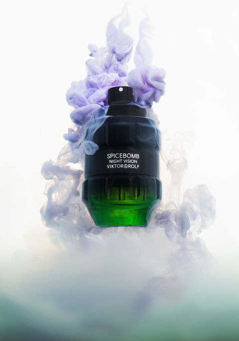 Perfume bottle with purple and green smoke effect.