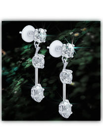 Diamond drop earrings on dark background.
