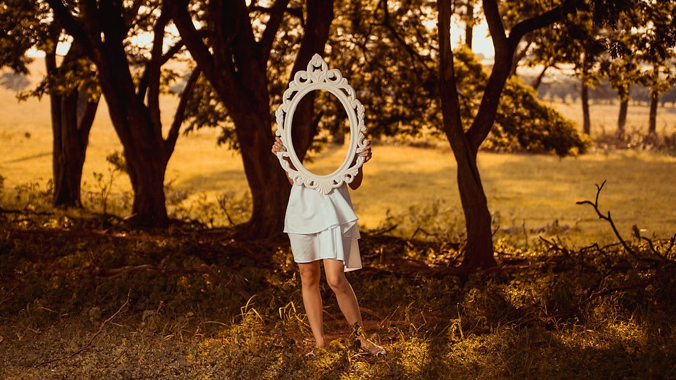 A woman carrying a mirror through a sunlit forest — seeing yourself clearly