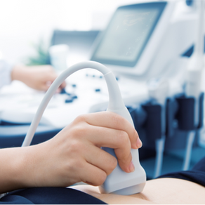 A hand operates an ultrasound transducer on a woman's abdomen. 