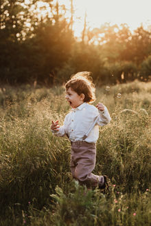 kisfiú szalad a réten, család fotózás