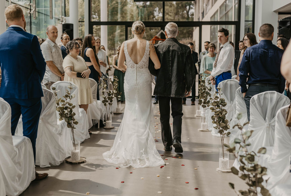 "Father walking the bride down the aisle, both sharing a heartfelt and emotional moment as they approach the altar."