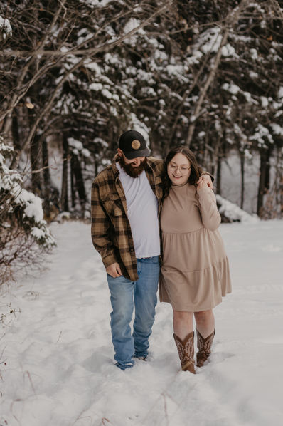 "A couple enjoys a romantic winter walk, the snow falling softly around them as they make their way through the winter wonderland."
