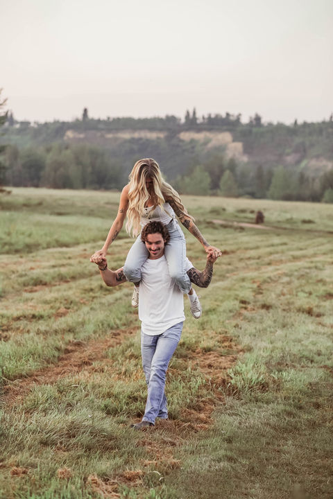 Couple doing a piggyback ride during their engagement session in Edmonton, Alberta.
