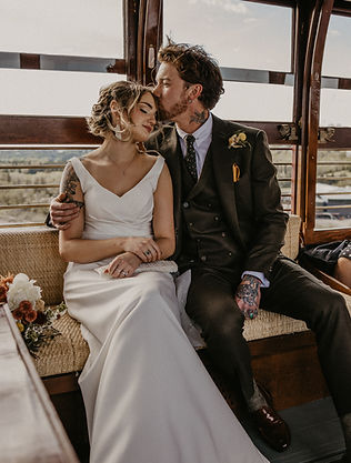 Bride and groom embracing while sitting on Edmonton Streetcars during a romantic Alberta elopement.
