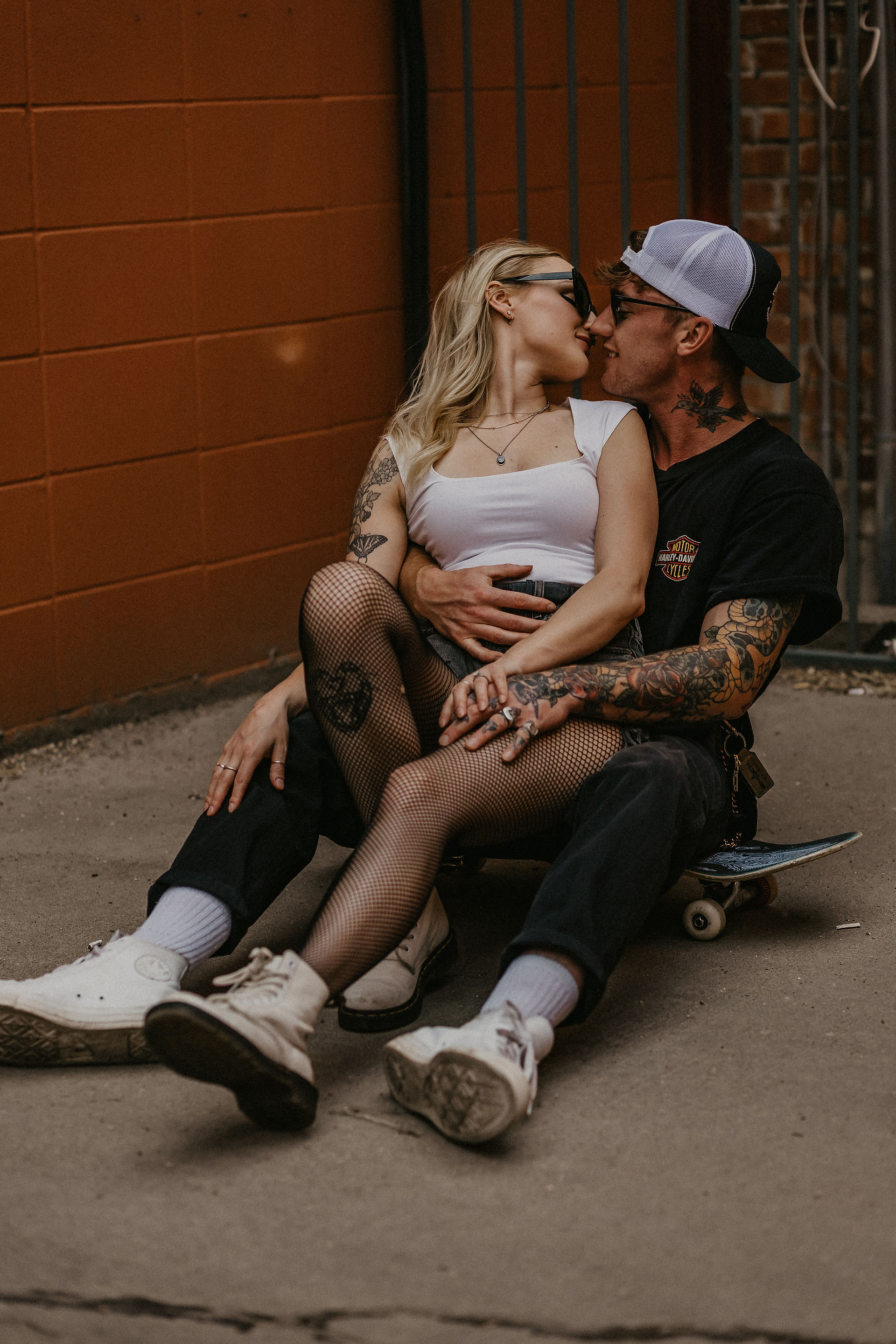 A couple sitting on a skateboard during a downtown couples session in edmonton alberta