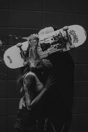 Couple posing with a skateboard during their engagement session in downtown Edmonton, Alberta.