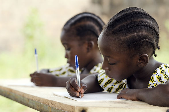 Close up of two young girls writing on paper