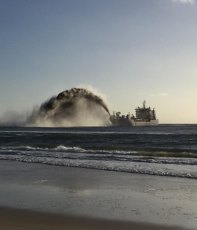 dredge doing rainbow dumping of sand