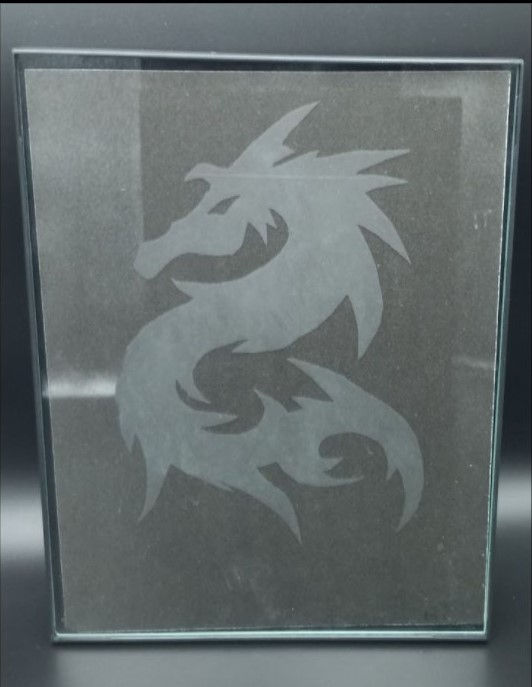 An image of a framed glass etching of a dragon