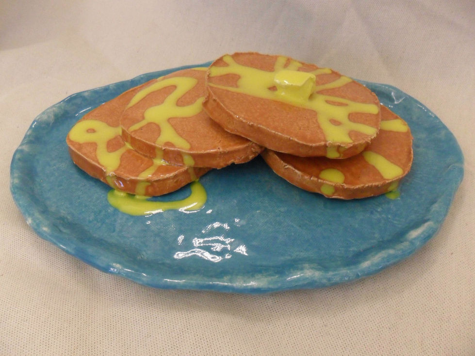 An image of a ceramic sculpture of pancakes with butter