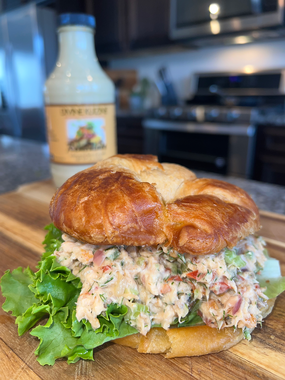 Smoked salmon croissant sandwich layered with crispy lettuce and sautéed peppers