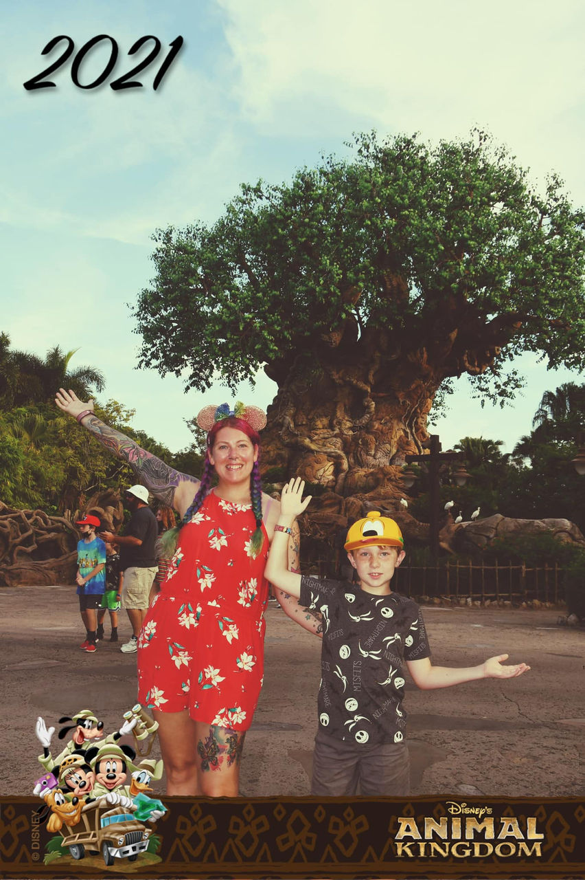 2021 family photo at Animal Kingdom with two happy people posing Allonsy Travel