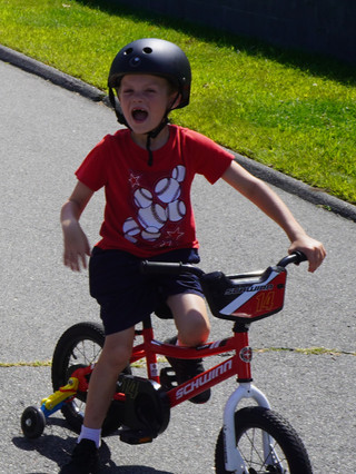 a kid in red with proper gears learning how to bike