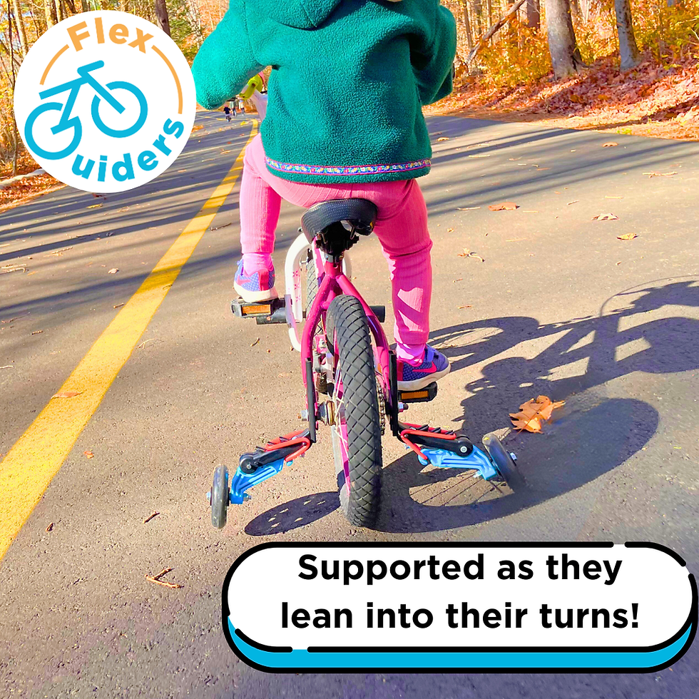 Child in green jacket and pink pants rides bike with training wheels on sunny path. Text: "Supported as they lean into their turns!"