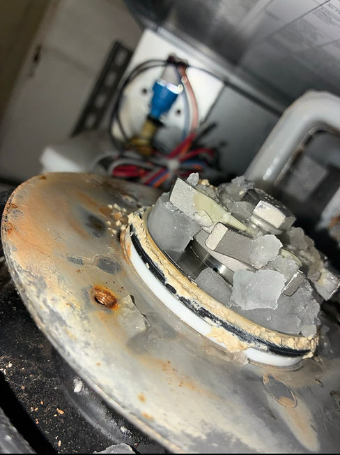 Before commercial ice machine preventive maintenance: mineral scale and residue buildup around a water-distribution component and ice-contact area.