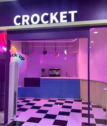 보라색 외관과 체크무늬 바닥의 CROCKET 매장 입구
