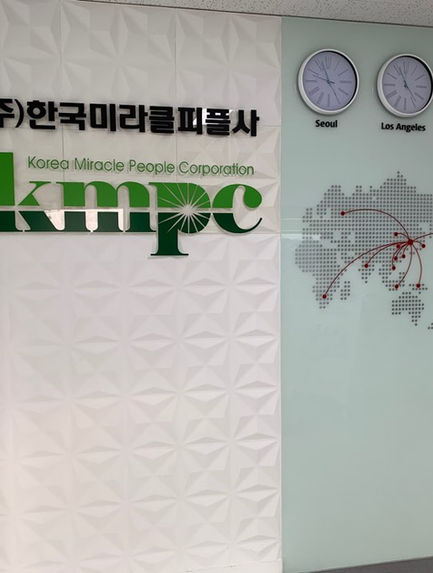 (주)한국미라클피플사 KMPC 로고와 세계 지도가 있는 사무실 벽면