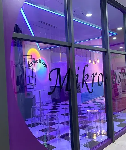 보라색 조명과 Mikrom의 글자가 적힌 세련된 교육 공간 입구