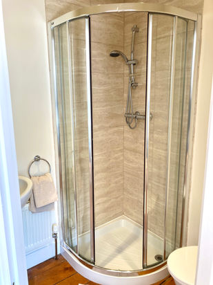 Corner shower enclosure in a bathroom