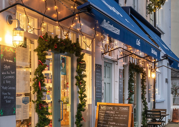 Traditional shop front with awning with Christmas lights and hand-written A-frame blackboard
