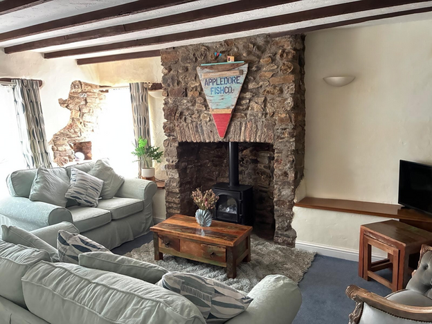Living room with stone fireplace and wood burner